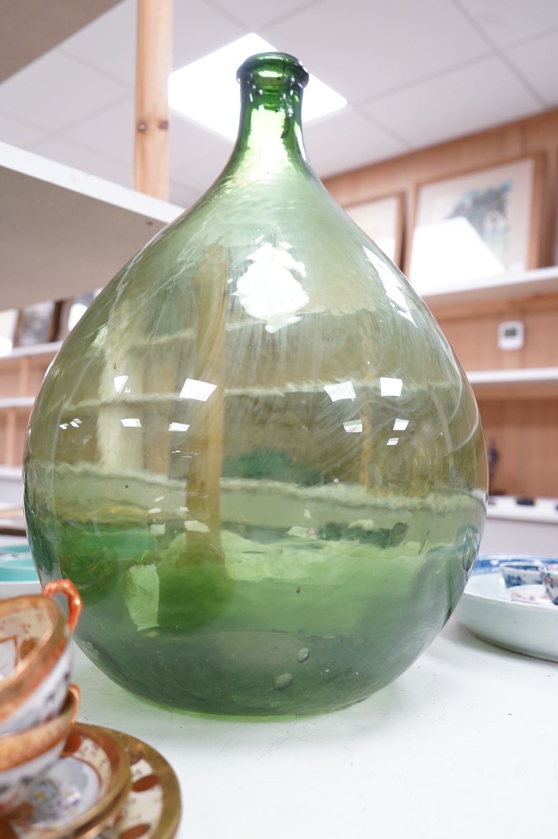 A large green glass carboy 51cm high